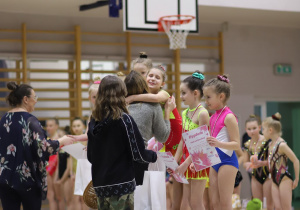 Na zdjęciu znajdują się gimnastyczki, biorące udział w zawodach