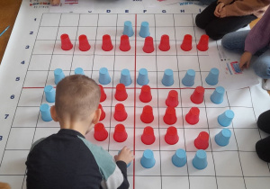 Na zdjęciu widać uczniów w czasie wykonywania zadania na macie edukacyjnej