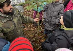 Na zdjęciu widać uczniów podczas spaceru w lesie.