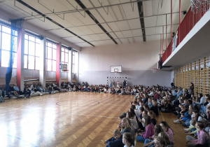 Uczniowie z klas 4-8 siedzący w sali gimnastycznej podczas wyborów do SU