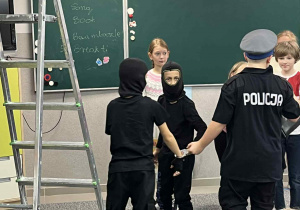 Na zdjęciu widac uczniów, odgrywających role w przedstawieniu.