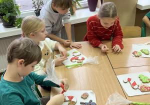 Na zdjęciu widać uczniów, dekorujących pierniki.