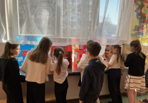 Na zdjęciu znajdują się uczniowie, którzy oglądają lapbooki.