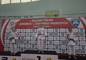 Na zdjęciu znajduje się Ola Zielińska, stojąca na podium, wraz z innymi zawodniczkami.
