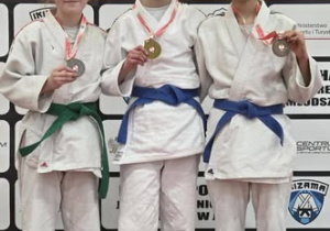 Na zdjęciu znajduje się Ola Zielińska, stojąca na podium, wraz z innymi zawodniczkami.