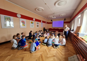 Na zdjęciu widać uczniów, znajdujących się w sali w Muzeum Tradycji Niepodległościowych. Wykonują zadania, pracując w grupach.