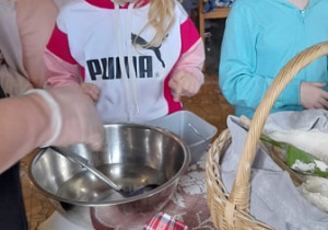 Na zdjęciu znajdują się uczennice wybierające produkty potrzebne do pieczenia chleba.