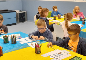 Na fotografii znajdują się uczniowie pracujący na warsztatach w Kolejkowie.